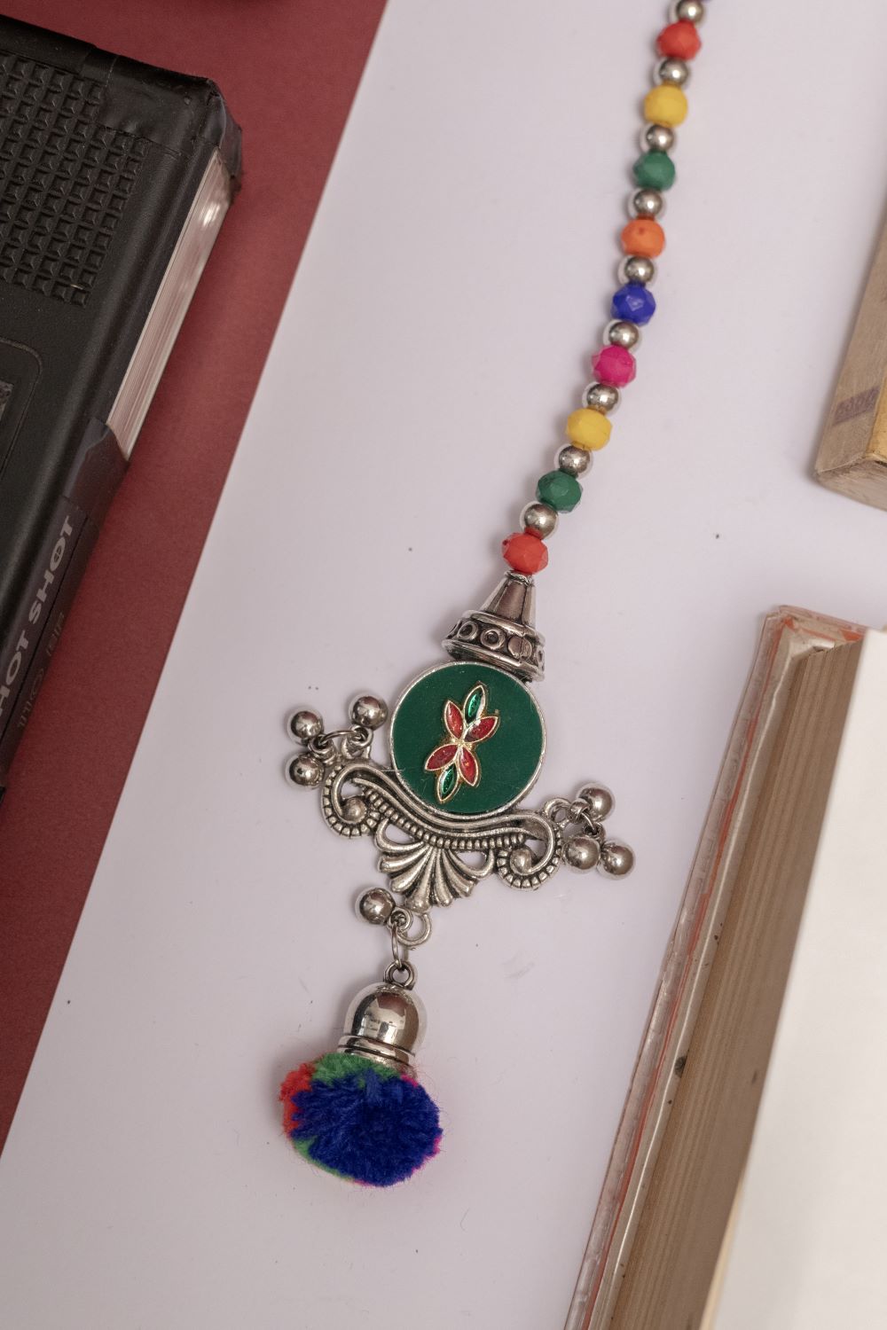 Multicolor Beaded Oxodise Tika with Red Floral Center & Pom Pom